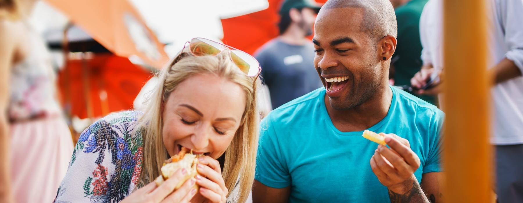 a man and a woman eating food at local restaurant