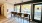 long  countertop with stools in front of large windows with pool view